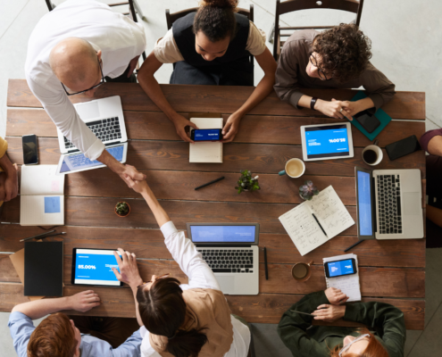 Cybalink remote team collaborating with laptops to improve productivity using AI-enabled outsourcing.