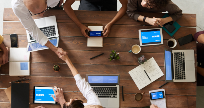 Cybalink remote team collaborating with laptops to improve productivity using AI-enabled outsourcing.